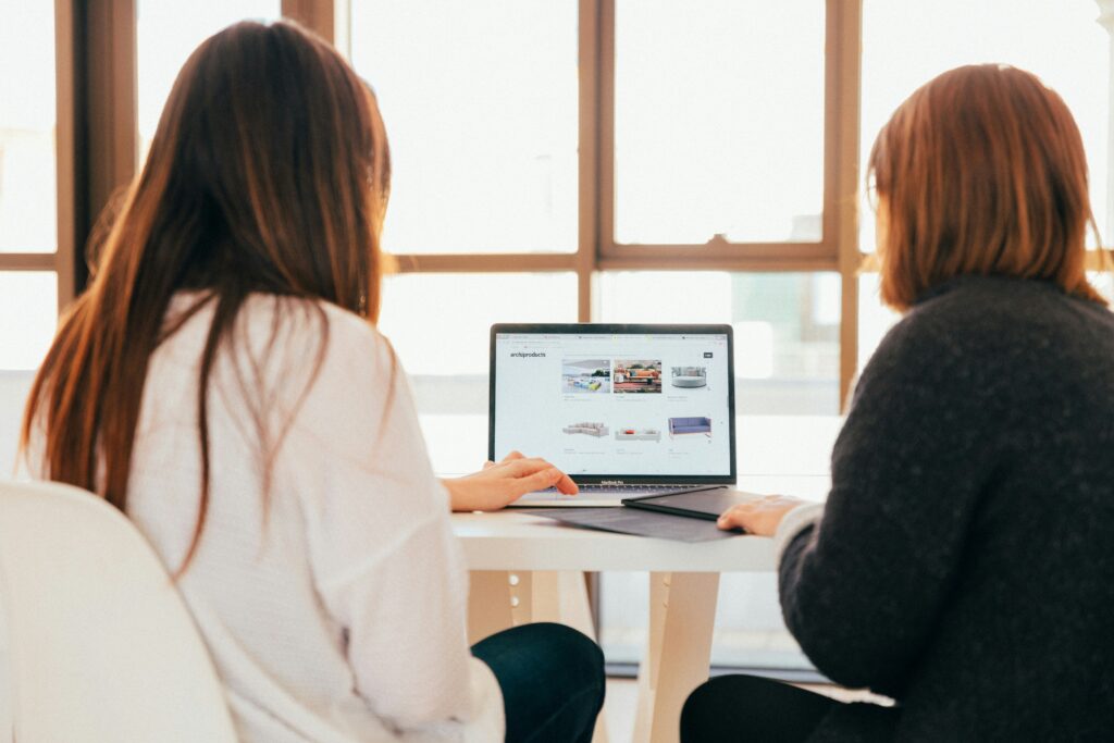 women working together on a laptop for landing page essentials